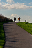 Ein Paar auf einem Motorrad, das eine Fahrt in der Nähe des Meeres genießt, Niederlande