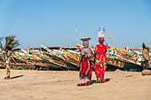 Woman at the colorful fishing boats at the beach in Tanji, Gambia, West Africa,