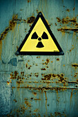 Radiation warning on old rusted door.