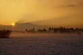Sonnenaufgang bei Schneelage und Morgennebel im südlichen Salzburg, Österreich
