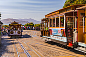 Two cable cars and a crowd boarding at Hyde Street Station, San Francisco, California, USA
