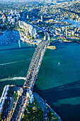 Blick von oben auf die Sydney Harbour Bridge und die Stadt Sydney, die Innenstadt und die Uferpromenade.