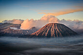Vulkan Mount Bromo, ein Somma-Vulkan und Teil der Tengger-Bergkette, der Kegel erhebt sich über Nebel in der Landschaft.
