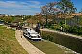 Boat going through Fonserannes lock staircase, Ecluses de Fonserannes, Canal du Midi, UNESCO World Heritage Canal du Midi, Occitania, France