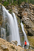 Frau beim Wandern steht vor Wasserfall Cirque de Saint-Meme, Naturreservat Hauts de Chartreuse, Chartreuse, Vercors, Savoien, Savoyen, Frankreich