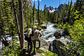United States, Idaho, Stanley, Senior couple standing next to rushing stream near Sun Valley