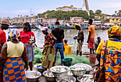 Fischmarkt und Fischerhafen in Elmina mit Blick auf die Festung São Jago da Mina in der Central Region im Westen von Ghana in Westafrika