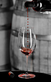 USA, Staat Washington, Woodinville. Einströmender Rotwein wird in der Luft aufgefangen, bevor er das Weinglas berührt.