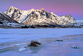 Frozen lake, mountains in the background with beautiful winter sky in Lofoten, Norway.