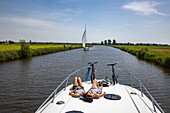 Young adult daughter and mother on the deck of a Le Boat Elegance houseboat on the Nieuw Wijmerts river, Woudsend, Friesland, The Netherlands, Europe