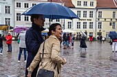 Couple with umbrella at Raekoja Plats Town Hall Square in the rain, Tallinn, Harju County, Estonia, Europe