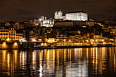 Reflection of lights in the Douro river overlooking Ribeira old town and historic center at night, Oporto, Oporto, Portugal, Europe