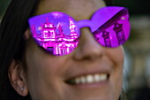 Spiegelung des Mateus-Palast in magentafarbener Sonnenbrille einer lächelnden jungen Frau, Vila Real, Vila Real, Portugal, Europa