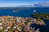 Aerial view of the city with expedition cruise ship World Voyager (nicko cruises) in the distance, Sandhamn, Stockholm archipelago, Sweden, Europe