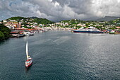 Luftaufnahme des alten Segelboot Carriacou (Savvy Sailing) in der St. George's Bay mit Kreuzfahrtschiff Le Dumont D'Urville (Ponant Cruises) am Pier im Hafen von St. George, Saint George's, Grenada, Karibik