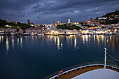 Bow of expedition cruise ship World Voyager (Nicko Cruises) in port overlooking city lights at dusk, St George&#39;s, St George, Grenada, Caribbean