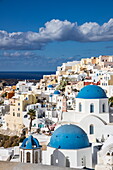 Blaue Kuppeln, griechisch-orthodoxe Kirche und Häuser auf Klippen, Oia, Santorini, Südliche Ägäis, Griechenland, Europa