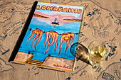 Custom hand painted menu and glass of white wine on table at Lombranos Taverna restaurant next to the pier, Fira, Santorini, South Aegean, Greece, Europe