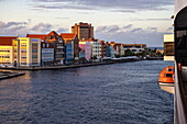 Side of expedition cruise ship World Voyager (nicko cruises) showing Dutch influenced architecture of buildings along Handelskade Street in Punda, Willemstad, Curaçao, Netherlands Antilles, Caribbean