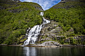 Seekajak vor Wasserfall im Geirangerfjord, Geiranger, Møre og Romsdal, Norwegen, Europa
