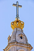 Durchsichtiges Kreuz auf der goldenen Krone an der Spitze der Basilika Nossa Senhora do Rosário, Fatima, Portugal
