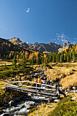 Hikers on bridge over Debantbach, Debanttal, Schober Group, Hohe Tauern National Park, East Tyrol, Tyrol, Austria