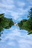 Double exposure view of the Spree river lined by leafy trees.