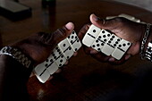 Hände halten Dominosteine während eines Spiels in Bar, Saint David, Grenada, Karibik