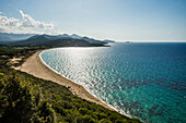 Sandy beach and mountains, Plage de Lozari, near LÎle-Rousse, Haute-Corse department, Corsica, Mediterranean Sea, France
