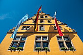 Fahnen hängen von einem gelben Gebäude in der Altstadt, Dinkelsbühl, Franken, Bayern, Deutschland, Europa