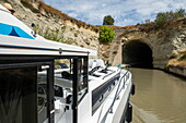 Ein Le Boat Horizon 5 Hausboot nähert sich dem Wassertunnel auf dem Canal du Midi, Le Malpas, Hérault, Frankreich, Europa
