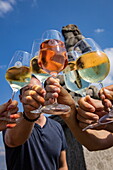 Nahaufnahme von Händen, die Weingläser halten und anstoßen, auf der Alten Mainbrücke (Pippinsbrücke), Kitzingen, Franken, Bayern, Deutschland, Europa