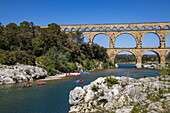 Pont du Gard ancient Roman aqueduct over the Gardon river with canoes, Vers-Pont-du-Gard, Gard, Occitanie, France, Europe