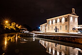 A Le Boat Horizon 5 houseboat docked at night at the visitor information office at the head of the Fonserannes locks on the Canal du Midi, Béziers, Hérault, France, Europe