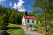 Mann und Frau wandern auf Starkenberger Weg, Kapelle Sinnesbrunn im Hintergrund, Starkenberger Weg, Sinnesbrunn, Lechtaler Alpen, Tirol, Österreich