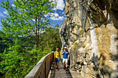 Mann und Frau wandern auf Starkenberger Weg an Felswand entlang, Starkenberger Weg, Via Claudia Augusta, Fernpass, Lechtaler Alpen, Tirol, Österreich