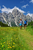 Man and woman hiking with Castello di Moschesin, Belluneser Höhenweg, Dolomites, Veneto, Venetia, Italy