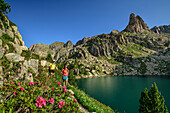Man and woman hiking in Aigüestortes National Park, Lake Estany Gran Amitges and Agulles Amitges in the background, Aigüestortes i Estany de Sant Maurici National Park, Pyrenees, Catalonia, Spain