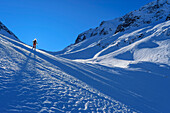 Woman on a ski tour ascending through the Scharzachtal to the Schwarzachscharte, Schwarzachtal, Zillertal Alps, Tyrol, Austria