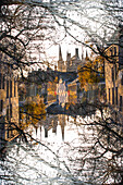 Fairy tale image of the rooftops and spires in medieval Bruges as seen from the side of one of the inner city canals.
