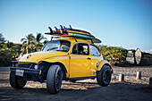 Off-road capable VW Beetle with surfboards on the roof at the surf spot on Playa Zicatela, Puerto Escondido, Oaxaca, Mexico, North America, Latin America, Pacific Ocean
