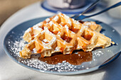 Waffle with strawberry sauce and powdered sugar in Cafe in Prerow, Mecklenburg-Western Pomerania, Baltic Sea, North Germany, Germany