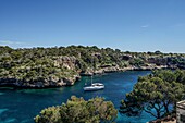 Entry of a yacht into the rocky bay of Cala Figuera, Santanyi, Mallorca, Spain