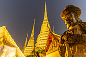 Riesige Wächterfigur Farang Guard und Chedi des buddhistischen Tempel Wat Pho in der Abenddämmerung, Bangkok, Thailand, Asien