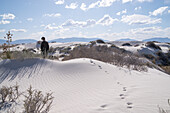 Woman walking on gypsum dunes in White Sands National Park.