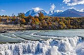 The spectacular rapids at the Cascada Rio Paine waterfall with the Torres del Paine mountains in the background, Chile, Patagonia, South America