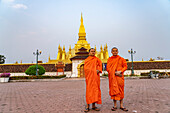 Mönche posieren vor dem Pha That Luang – Das Nationalsymbol von Laos in der Hauptstadt Vientiane, Laos, Asien