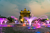 Bunt beleuchteter Brunnen am Siegestor Patuxai in der Abenddämmerung, Hauptstadt Vientiane, Laos, Asien