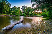 Long exposure on the stony bank of the river Saale in summer at sunset and blue sky, Jena, Thuringia, Germany