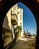 Stolzenfels Castle, view through a portal in neo-Gothic style to the Rhine terrace with palace, eagle column, palm trees and petunia decorations, Koblenz, Upper Middle Rhine Valley, Rhineland-Palatinate, Germany